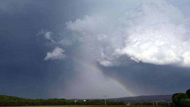 Wetter: Ein Regenbogen bildet sich vor dunklen Wolken. In Thüringen sind am Dienstag Gewitter und Starkregen möglich.