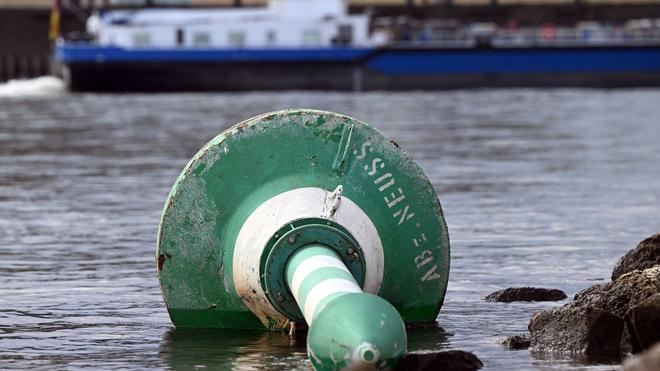 Unfall: Ein Frachtschiff fährt auf dem Rhein an einer wegen des niedrigen Wasserstandes umgefallenen Fahrwassertonne vorbei.