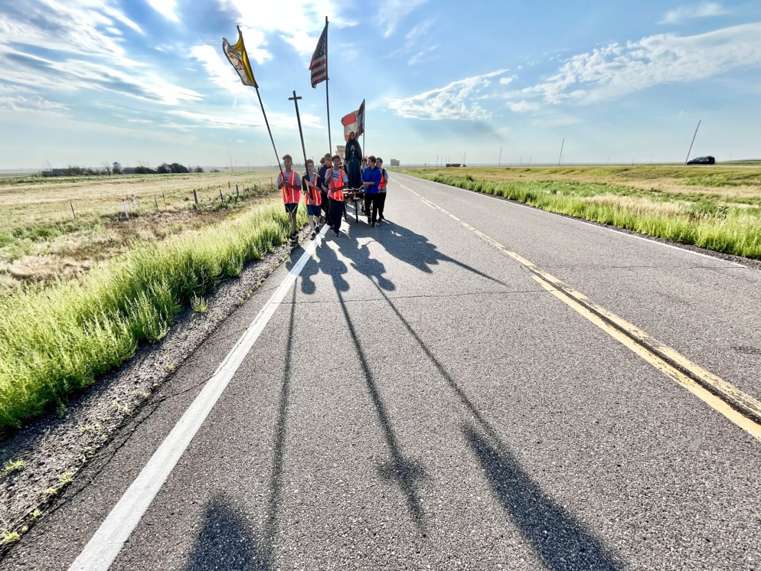 A Catholic parish against abortion rights begins a two-day walk on Interstate 70 west of Watkins, Colo. on Friday, Aug. 19, 2022.