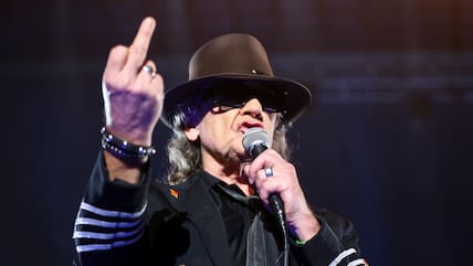 Der Musiker Udo Lindenberg steht 2017 in Kiel (Schleswig-Holstein) bei einem Konzert auf der Bühne in der Sparkassen Arena und reckt den Mittelfinger der rechten Hand hoch. (Archiv)