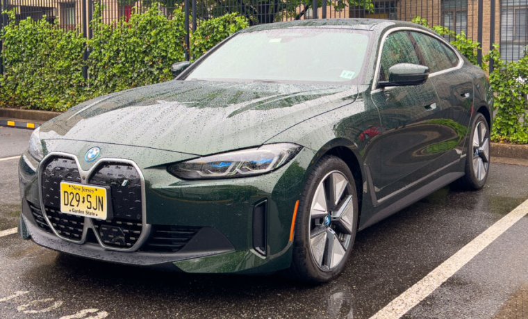 A green metallic BMW i4 seen in the rain