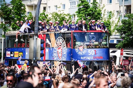 Mit dem „Aufstiegsexpress“ fährt die Mannschaft von Holstein Kiel durch die Stadt – und wird von den eigenen Fans gefeiert.