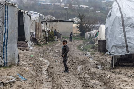 Syrien, Idlib: Ein kleiner Junge steht auf schlammigem Boden in dem Flüchtlingslager im Norden Syriens nahe der syrisch-türkischen Grenze, das durch Unwetter mit Sturm und Regen beschädigt worden ist. 