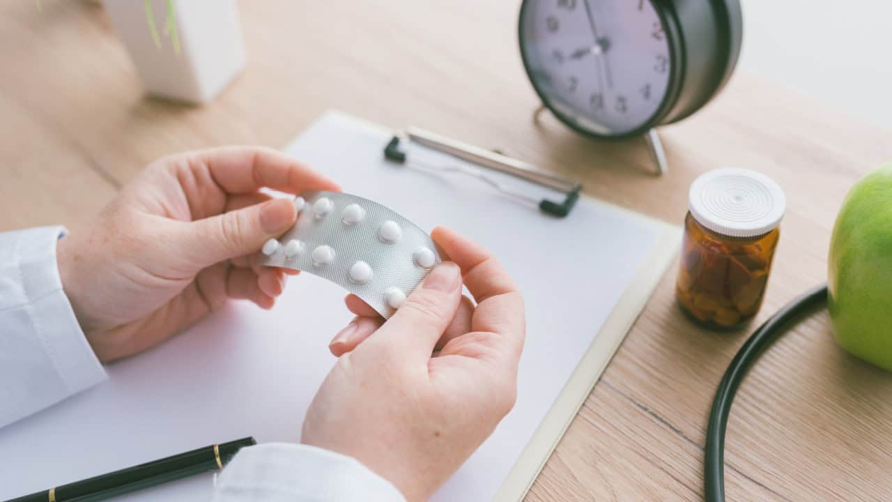 Female doctor holding unlabeled generic tablets