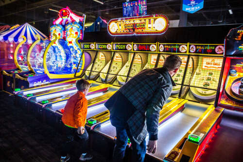 It's a good thing this kid is too young to bet on Skee-Ball, because his dad is getting <em>beat</em>.