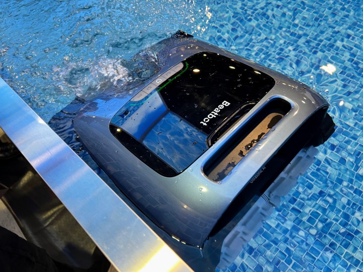 A floating Beatbot robot collects debris from the edges of a pool.