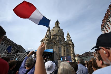 Ein Festbesucher schwenkt eine Frankreich-Fahne während der Rede von Emmanuel Macron.