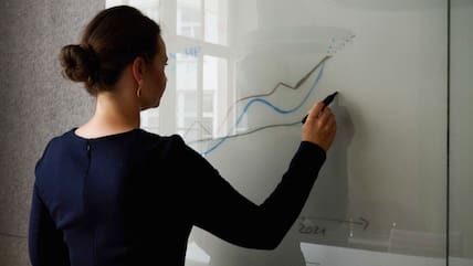 Eine Frau steht an einem Whiteboard in einem Konferenzraum.