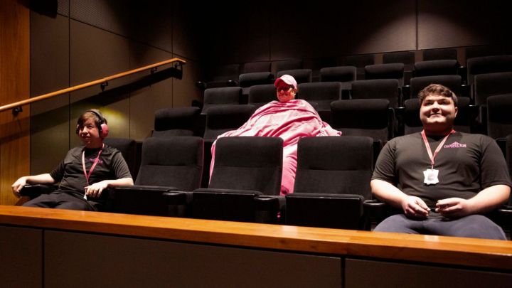 People in a movie theater looking ahead and smiling.