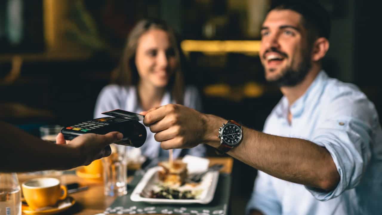 man paying bill at fancy restaurant