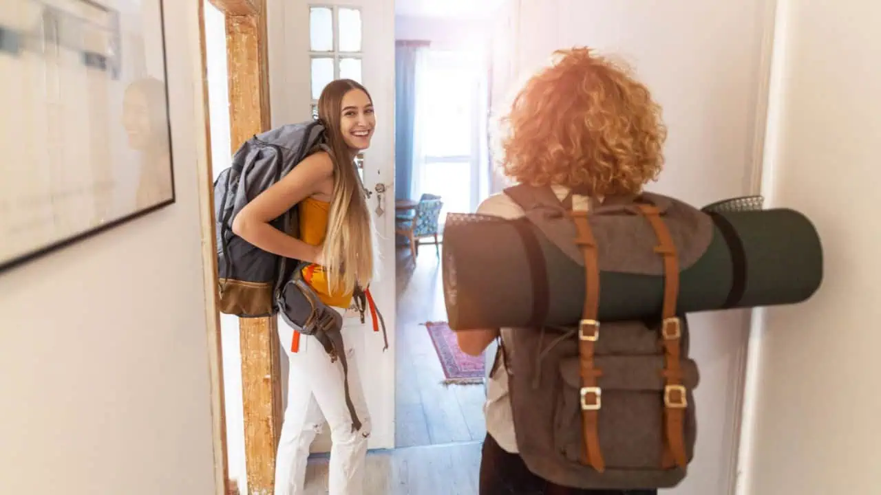 women with backpacks arriving to a youth hostel