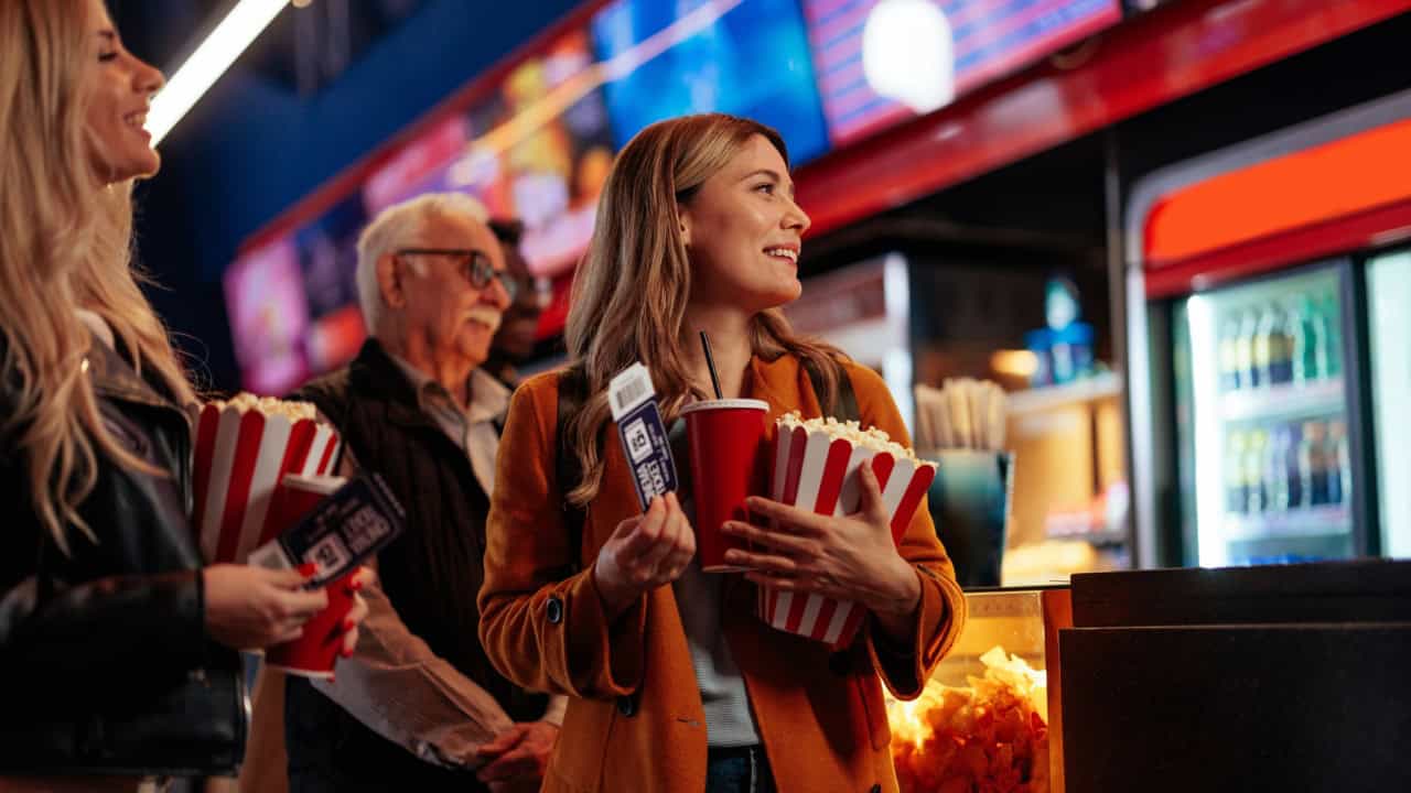 queueing up in a movie theater to watch a movie