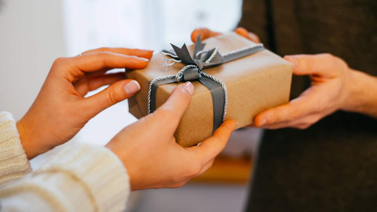 young woman gives a gift in a box