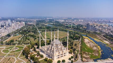 Blick auf die Stadt Adana in der Türkei mit großer Moschee, Park, einem Flussund hellen Gebäuden