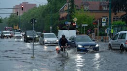 22.05.2024, Brandenburg, Potsdam: Ein Radfahrer und Autos fahren im Schritttempo durch die überflutete Zeppelinstraße. Starkregen hat am späten Nachmittag in Potsdam die Kreuzung Zeppelinstraße/Geschwister-Scholl-Straße unter Wasser gesetzt. Foto: Georg Moritz/dpa +++ dpa-Bildfunk +++