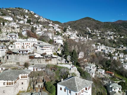 Blick über weiße Häuser an den Hängen eines Berges in Makrinitsa, Pilion-Halbinsel