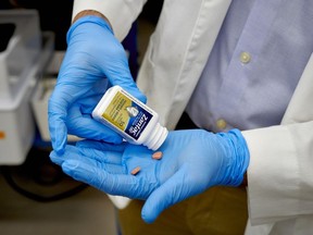 A researcher prepares to test a bottle of Zantac 150