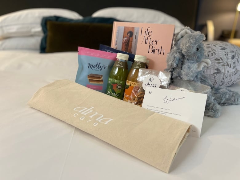 A selection of snacks and gifts is pictured on a hotel room bed.