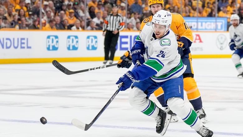 Two hockey players race for the puck.