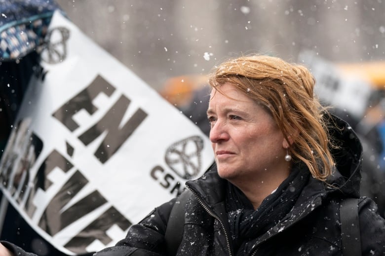 a blonde white woman outside at a protest 