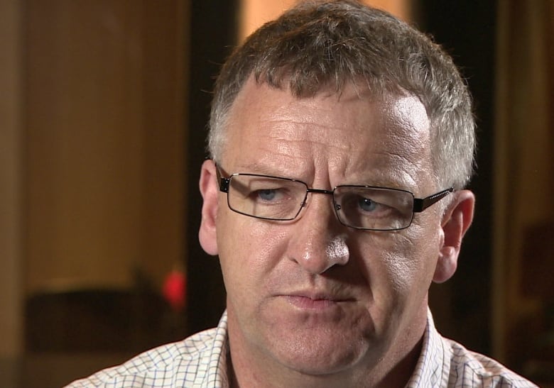 A close up shot of a man wearing glasses. 