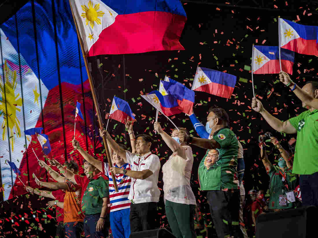 Ferdinand "Bongbong" Marcos Jr. and running mate Sara Duterte wave Philippine flags during their last campaign rally before the election on May 07, 2022 in Paranaque, Metro Manila, Philippines. (Photo by Ezra Acayan/Getty Images)