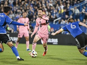 Inter Miami's Lionel Messi (10) pushes forward as CF Montreal's Fernando Alvarez (4) and Samuel Piette (6) defend during first half MLS soccer action against CF Montreal in Montreal, Saturday, May 11, 2024.