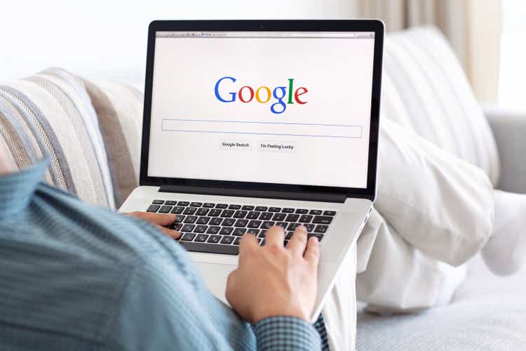 man sitting the MacBook retina with site Google on screen