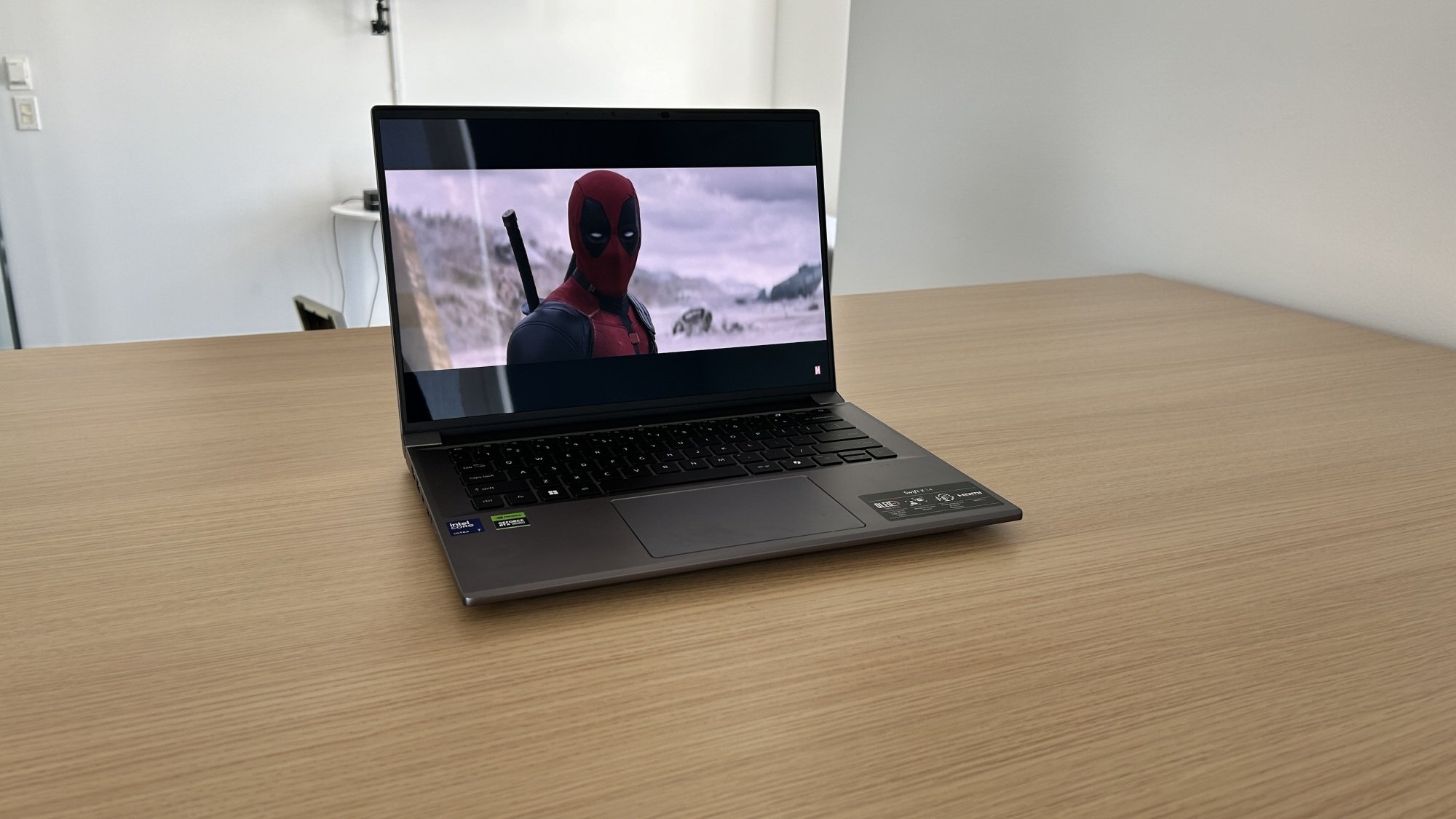 Acer Swift X 14 on a table displaying the Deadpool and Wolverine trailer