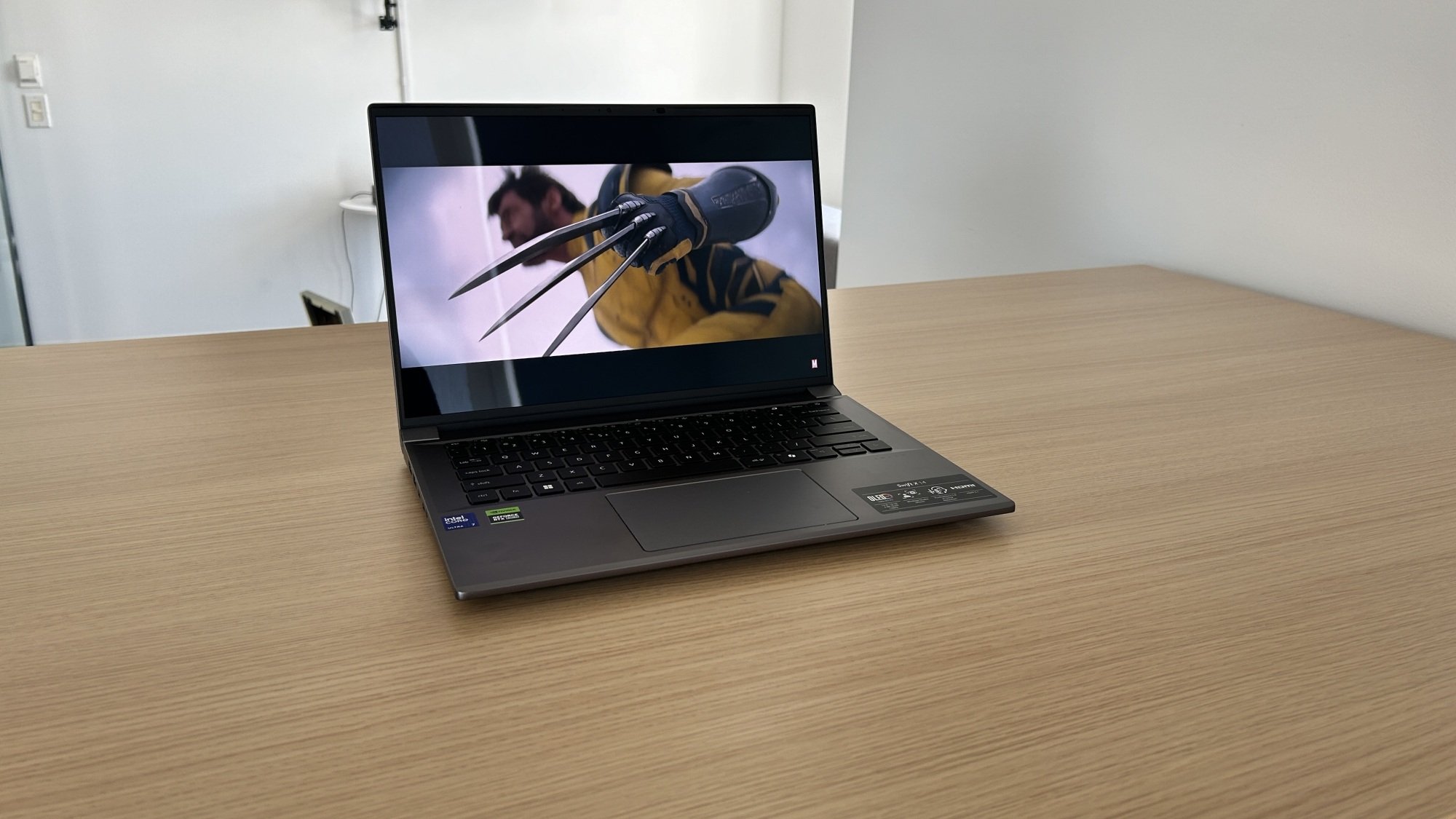 Acer Swift X 14 on a table displaying the Deadpool and Wolverine trailer