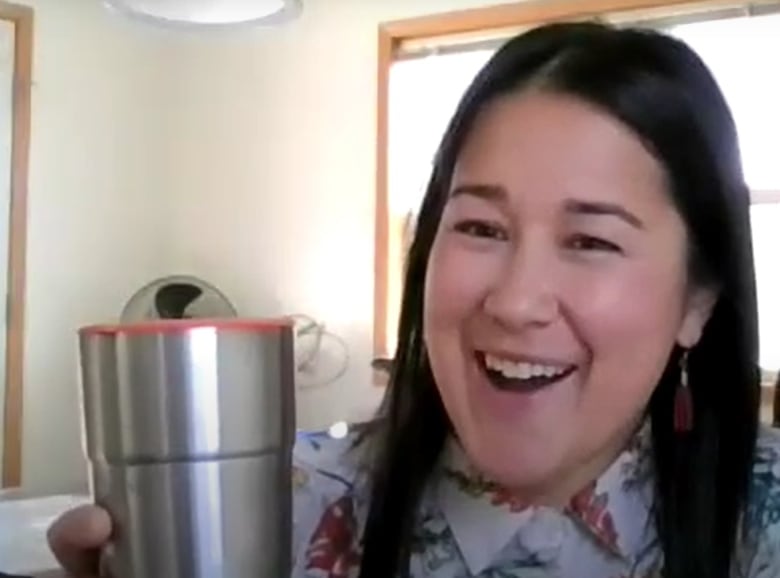 A woman shows a reusable cup.