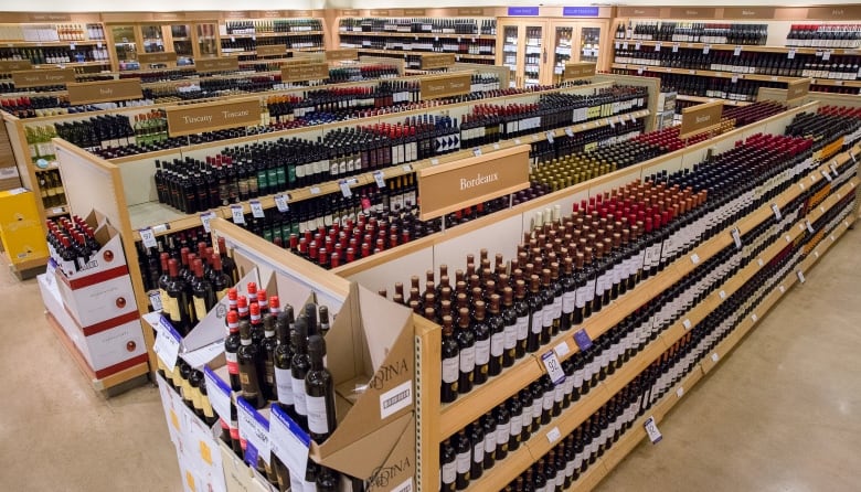 Bottles of wine on shelves under signs that say Bordeaux and Tuscany.