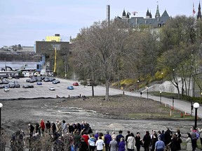 The future site of Thunderhead: Canada's 2SLGBTQI+ National Monument is marked out in the dirt by a translucent ring behind political leaders and members of the LGBT Purge Fund as they participate in a ground-breaking ceremony in Ottawa, on Wednesday, May 1, 2024.