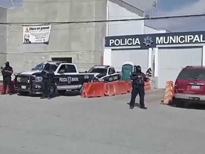 In this image made from video, Mexico's police officers stand guard at the Ensenada station in Ensenada, Mexico, Thursday, May 2, 2024.