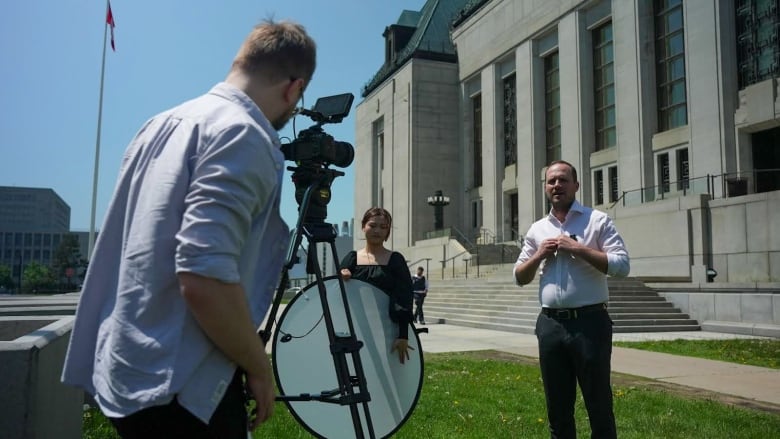 Liberal MP Nate Erskine-Smith filming a social media video with new hire filmmaker Kristian Podlacha in front of the Supreme Court. 