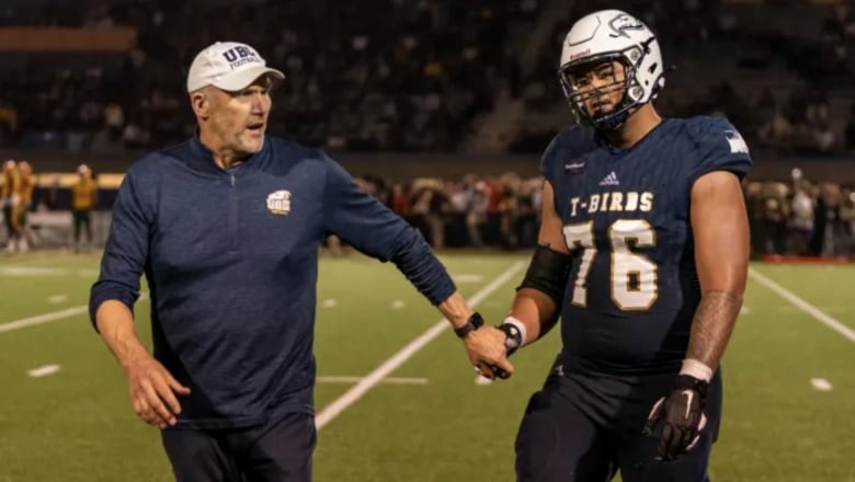 A coach and player speak during a game.