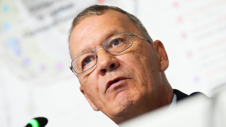 A closeup of a man at a press conference.