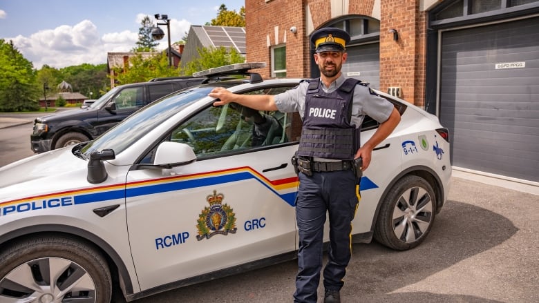 Sgt. Shaun Vickery, national traffic programs and operational technologies,  poses in front of one of the RCMP's Teslas.