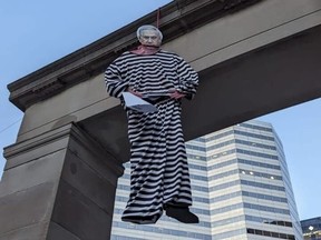 A picture of Benjamin Netanyahu's face is attached to a figure with black and white striped shirt and pants hanging from an arch.