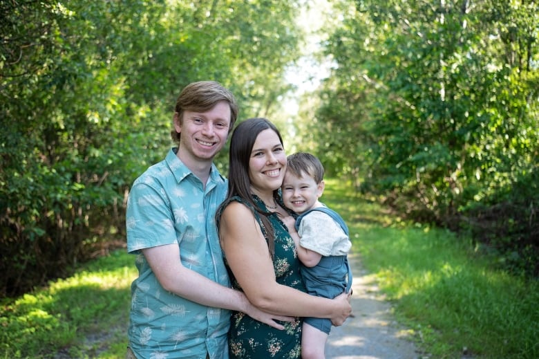 A man, woman and toddler pose in a  portrait