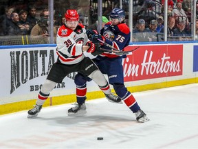 Moose Jaw Warriors forward Rilen Kovacevic (39) battles with Saginaw Spirit defenceman Jorian Donovan during semifinal action at the 104th Memorial Cup.