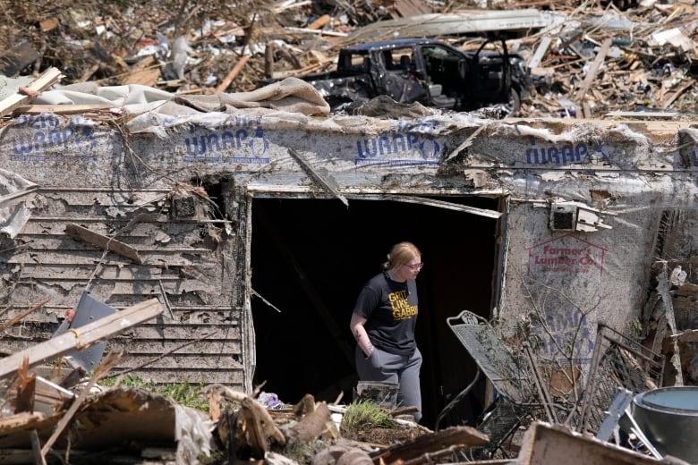 A woman walks out of the basement of a tornado damaged home, Wednesday, May 22, 2024, in Greenfield, Iowa.