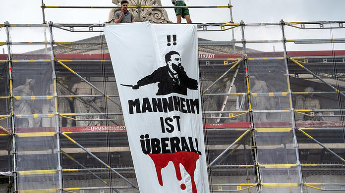 Die Polizei ermittelt nun gegen die beiden Männer auf dem Gerüst wegen des aufgehängten Banners. Der Vorwurf: Volksverhetzung. Sie sind offenbar Mitglieder der rechten Identitären.