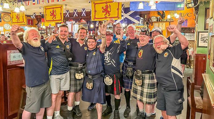 Thomas Patterson (4. von links) und Colin O'Hara (5. von links) feiern mit ihren Freunden im Irish Pub Kennedy's Bar und Restaurant. Sie begleiten die schottische Fußballnationalmannschaft bei all ihren Spielen bei der Europameisterschaft. Foto: privat