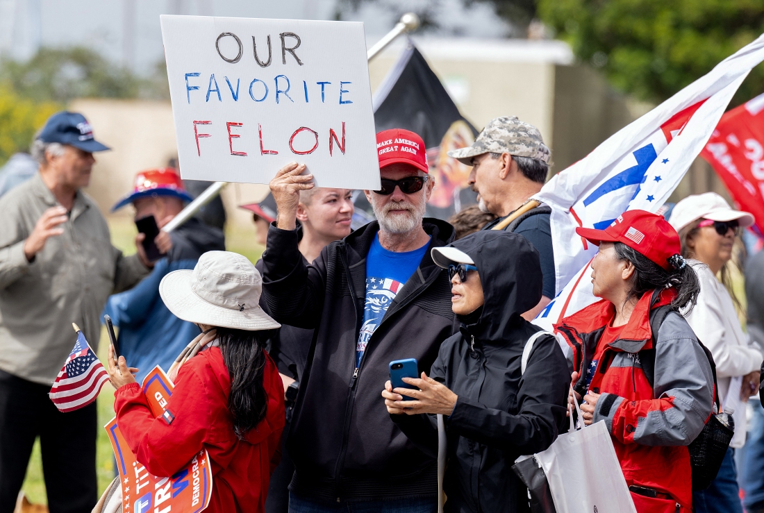 A supporter holds a sign reading 