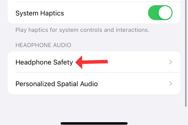 Screenshot of the Sounds & Haptics menu with an arrow next to the Headphone Safety option.