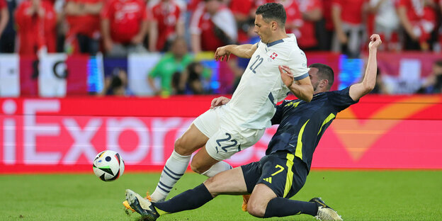 Fabian Schär von der Schweiz und Schottlands John McGinn (r) kämpfen um den Ball.