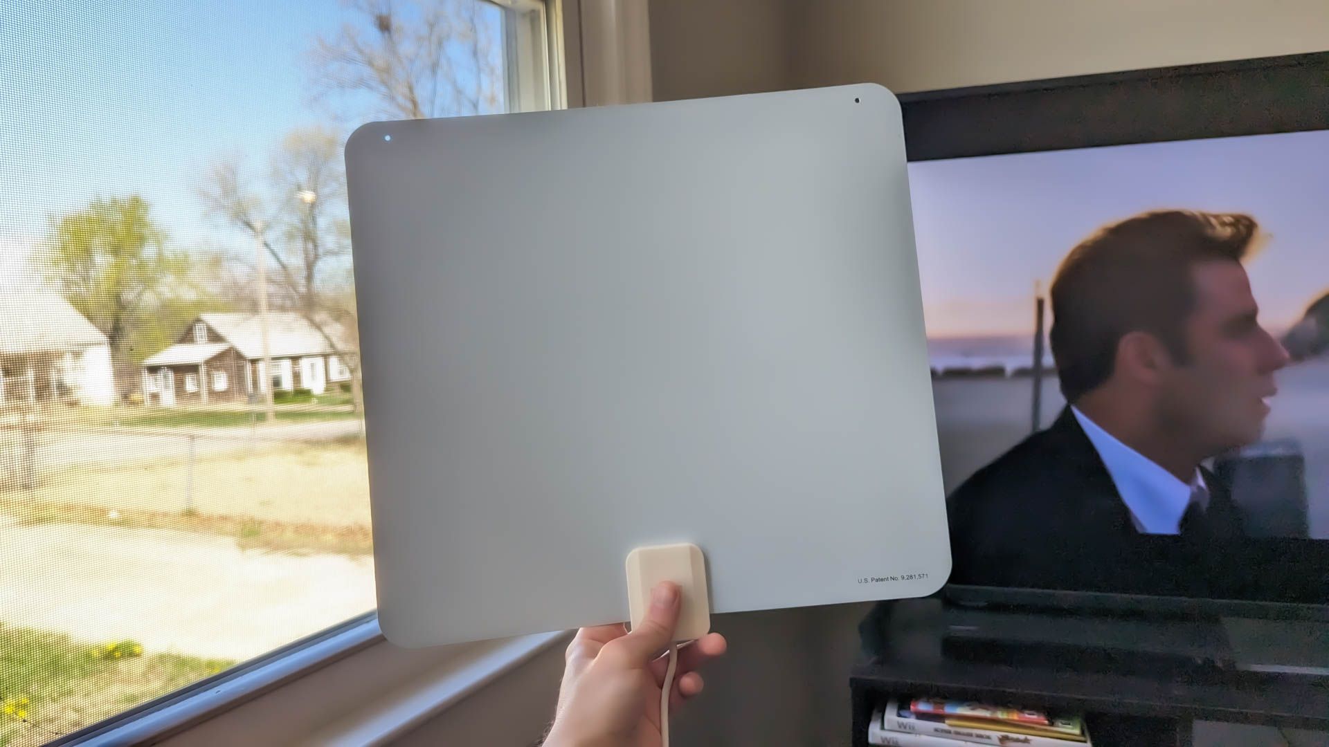 Person holding an indoor TV antenna