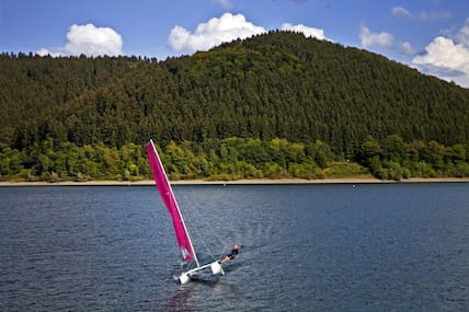 Maritime Szenen im Sauerland: Ein Segler braust mit seinem Katamaran über den Biggesee.