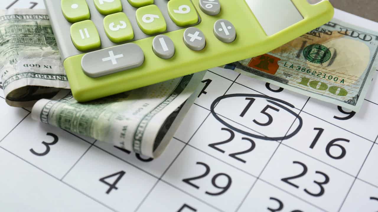 Budgeting Concept - Green calculator and money on calendar